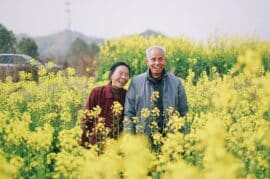 Happy couple in a fiend of yellow flowers