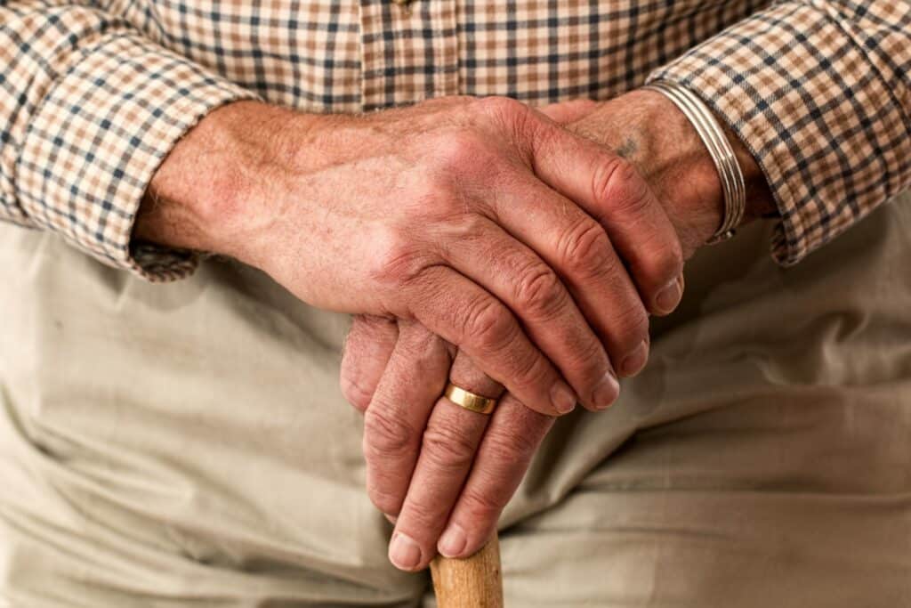 Older persons hands resting on a cane